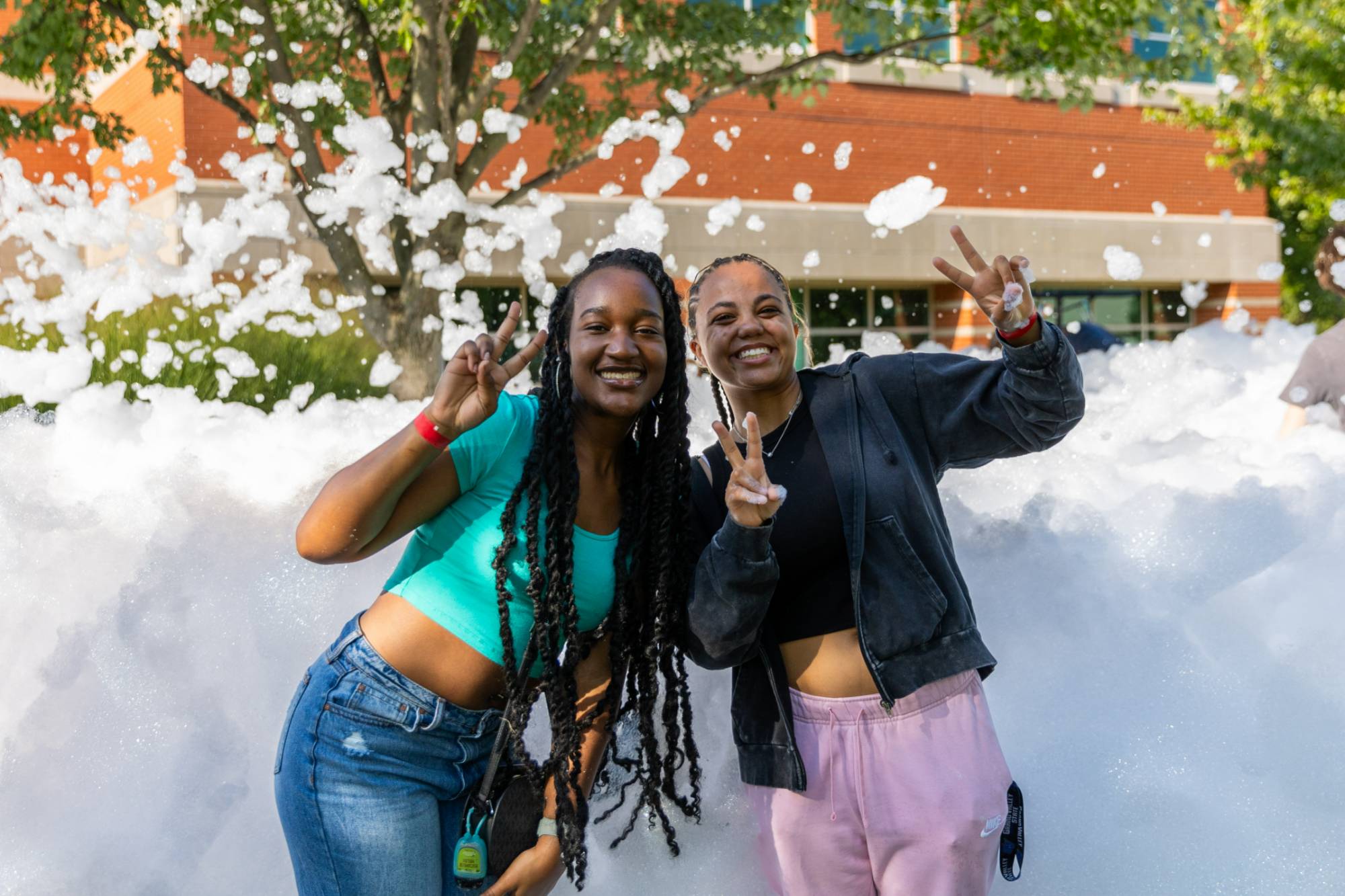 two female presenting students standing in front of a foam pit